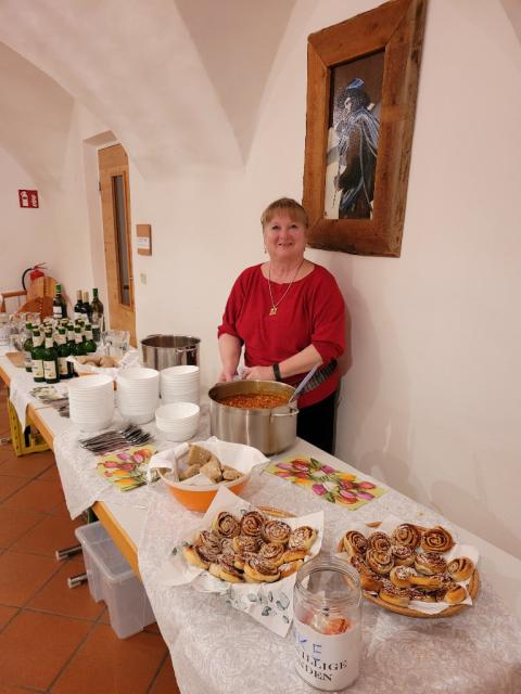 Frau hinter Tischen mit Buffet